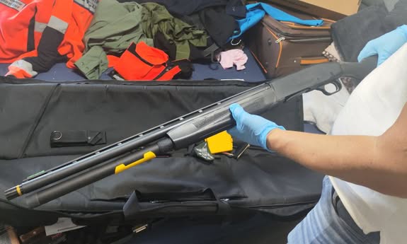 policjant trzyma w rę9kach długą broń.