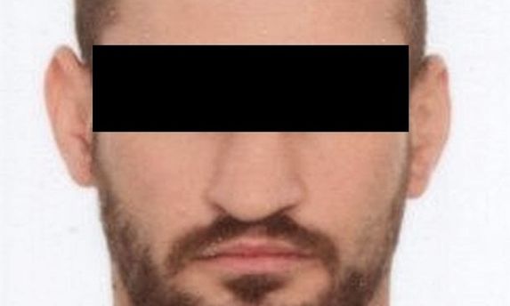 portret mężczyzny z zakrytymi czarnym prostokątem oczyma.
