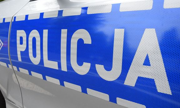 Napis Policja na bocznych drzwiach radiowozu.