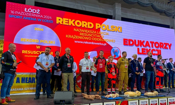Uczestnicy Największej Lekcji Resuscytacji Krążeniowo–Oddechowej, której głównym punktem była Próba Ustanowienia Oficjalnego Rekordu Polski w tej kategorii  stoją na scenie.