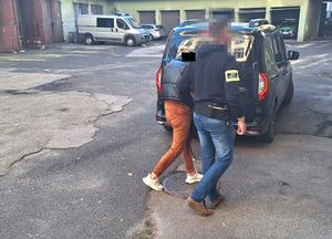 Funkcjonariusze prowadzą zatrzymanego.