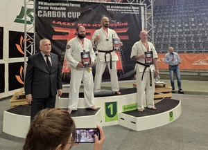 Trzech mężczyzn stoi na podium.