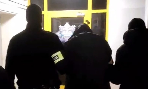 Funkcjonariusze prowadzą zatrzymanego mężczyznę.