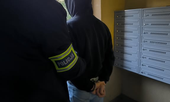 policjant stoi z zatrzymanym