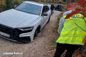 policjant robi zdjęcia skradzionego samochodu.