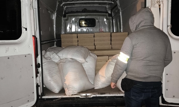 Funkcjonariusz w trakcie zabezpieczania tytoniu znajdującego się w pojeździe.