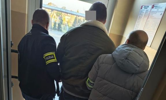 dwóch policjantów stoi z zatrzymanym.