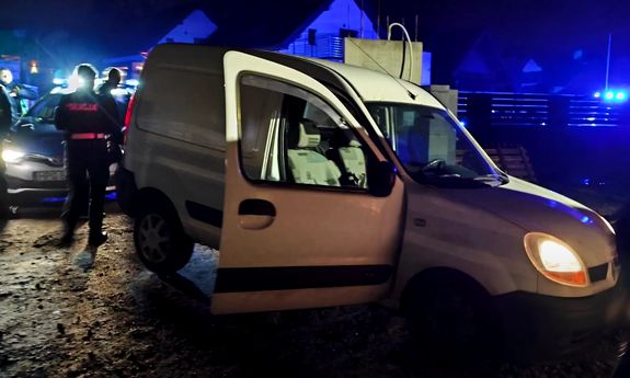 noc, biały samochód, obok radiowóz.
