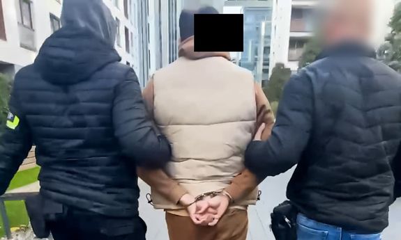 policjanci idą z zatrzymanym.