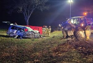 Miejsce wypadku. Uszkodzony samochód osobowy i traktor. Przy rozbitym samochodzie strażacy.