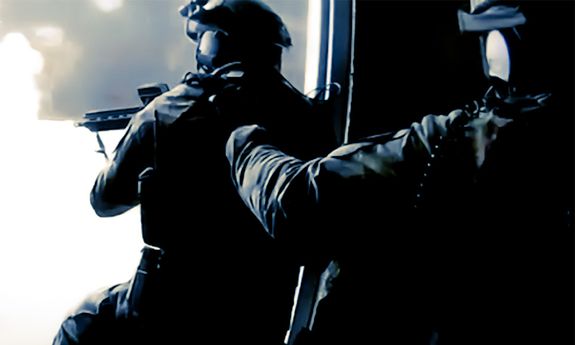 ciemno, policjanci uzbrojeni idą do drzwi.