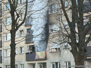 Kłęby dymu wydobywające się z jednego z mieszkań w budynku mieszkalnym.