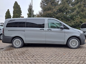 Zdjęcie przedstawia bok pojazdu typu BUS marki Mercedes-Benz w kolorze szarym