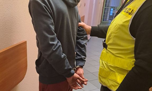 Policjant stoi z zatrzymanym.