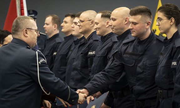policjant podaje rękę nowo przyjętemu policjantowi.