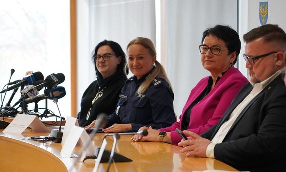 goście siedzą przy biurku.