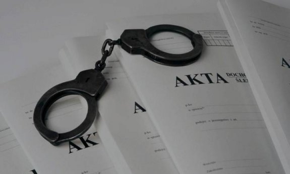 Kajdanki leżą na aktach sprawy.