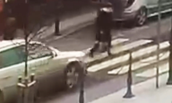 Stopklatka z nagrania wideo. Kobieta przechodząca przez przejście dla pieszych, w jej kierunku jedzie samochód.
