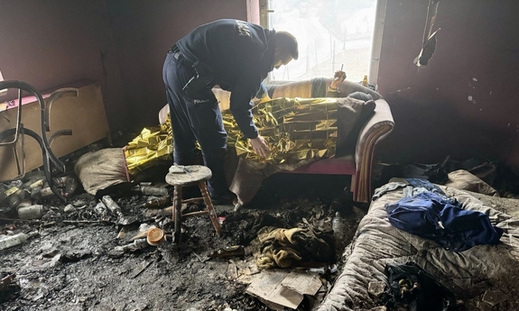Policjant okrywa bezdomnego.