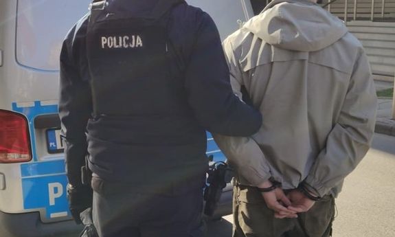 policjanci idą z zatrzymanym.