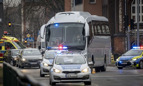 Radiowozy policyjne i inne pojazdy na ulicy.