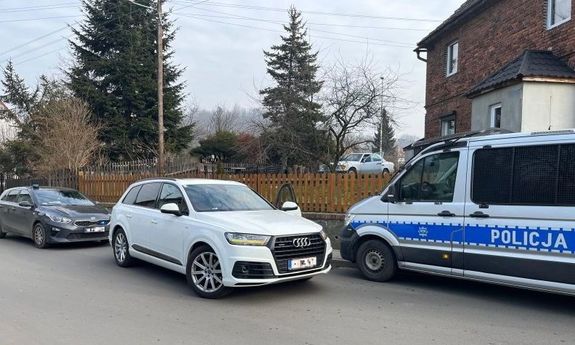 Białe audi, a przed nim policyjny radiowóz. Z tyłu widoczny jest radiowóz nieoznakowany.