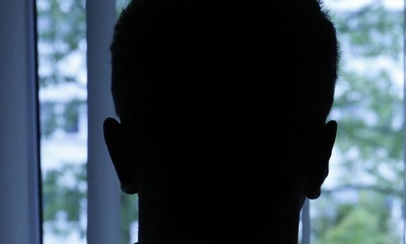 Czarna sylwetka mężczyzny stojącego przy oknie.
