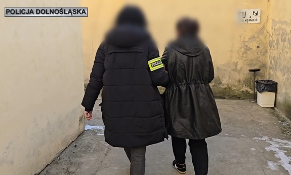 Policjantka. prowadzą zatrzymaną.