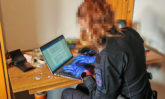 policjantka pisze na komputerze.