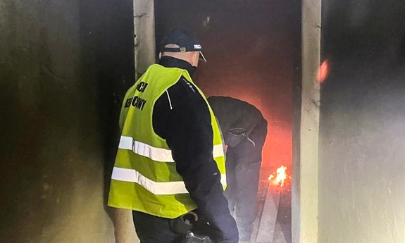 Dzielnicowy przeszukujący opuszczony budynek.