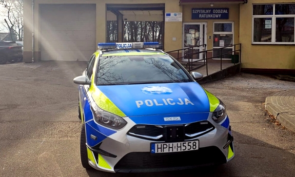 Na zdjęciu oznakowany radiowóz stoi pod szpitalnym oddziałem ratunkowym.