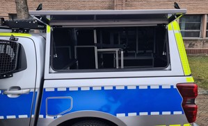 Zdjęcie przedstawia bok radiowozu oznakowanego typu pick-up Isuzu D-MAX
