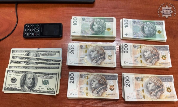 Pieniądze i telefon ułożone na stole.