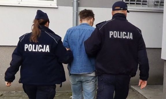 policjanci prowadzą zatrzymanego.