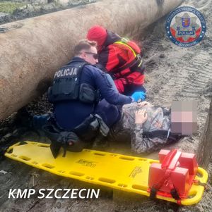 policjanci z ratownikami udzielają pomocy mężczyźnie.