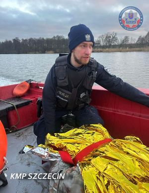 policjanci z ratownikami udzielają pomocy mężczyźnie.