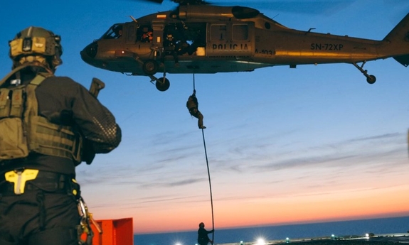 Kontrterrorysta obserwuje desant swoich kolegów ze śmigłowca Black Hawk.