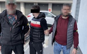Dwaj funkcjonariusze z zatrzymanym mężczyzną.