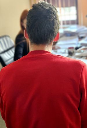 Zatrzymany mężczyzna podczas przesłuchania. Na rękach ma założone kajdanki.