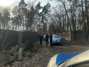 Na zdjęciu dwóch umundurowanych policjantów prowadzi odnalezioną kobietę do radiowozu.