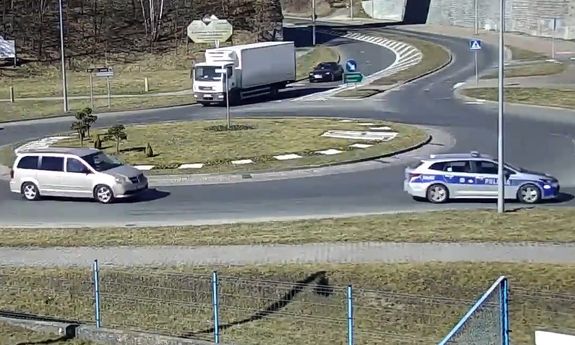 kadr z monitoringu, na rondzie policja eskortuje samochód z rodzącą.