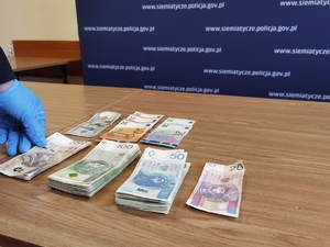 Pliki banknotów na stole.