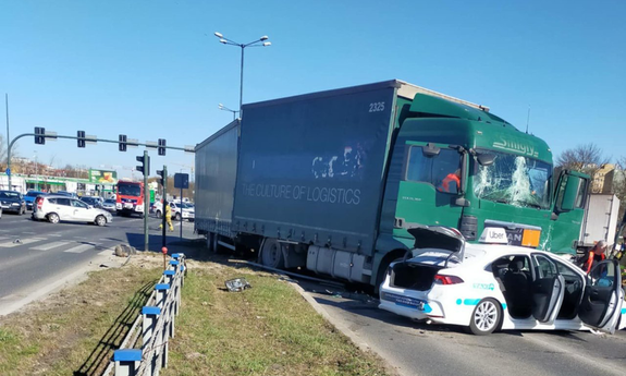 Zdjęcie ciężarówki i samochodu osobowego w miejscu wypadku drogowego.