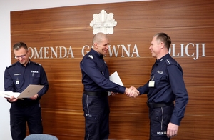 I Zastępca Komendanta Głównego Policji nadinsp. Roman Kuster podaje dłoń policjantowi w geście podziękowania.