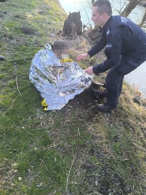 Policjant z mężczyzną uratowanym z wody.