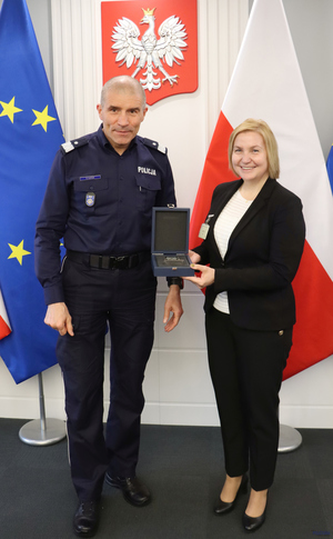 komendant podaje rękę najpierw kobiecie potem mężczyźnie.