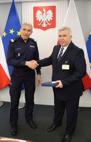 komendant podaje rękę najpierw kobiecie potem mężczyźnie.