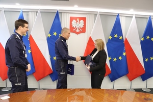 komendant podaje rękę najpierw kobiecie potem mężczyźnie.