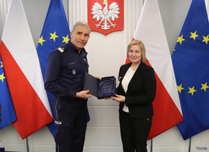 komendant podaje rękę najpierw kobiecie potem mężczyźnie.