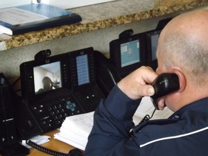 Policjant na stanowisku oficera dyżurnego KPP Dębica, odbiera telefoniczne zgłoszenie.